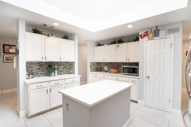 a kitchen with white cabinets and white appliances