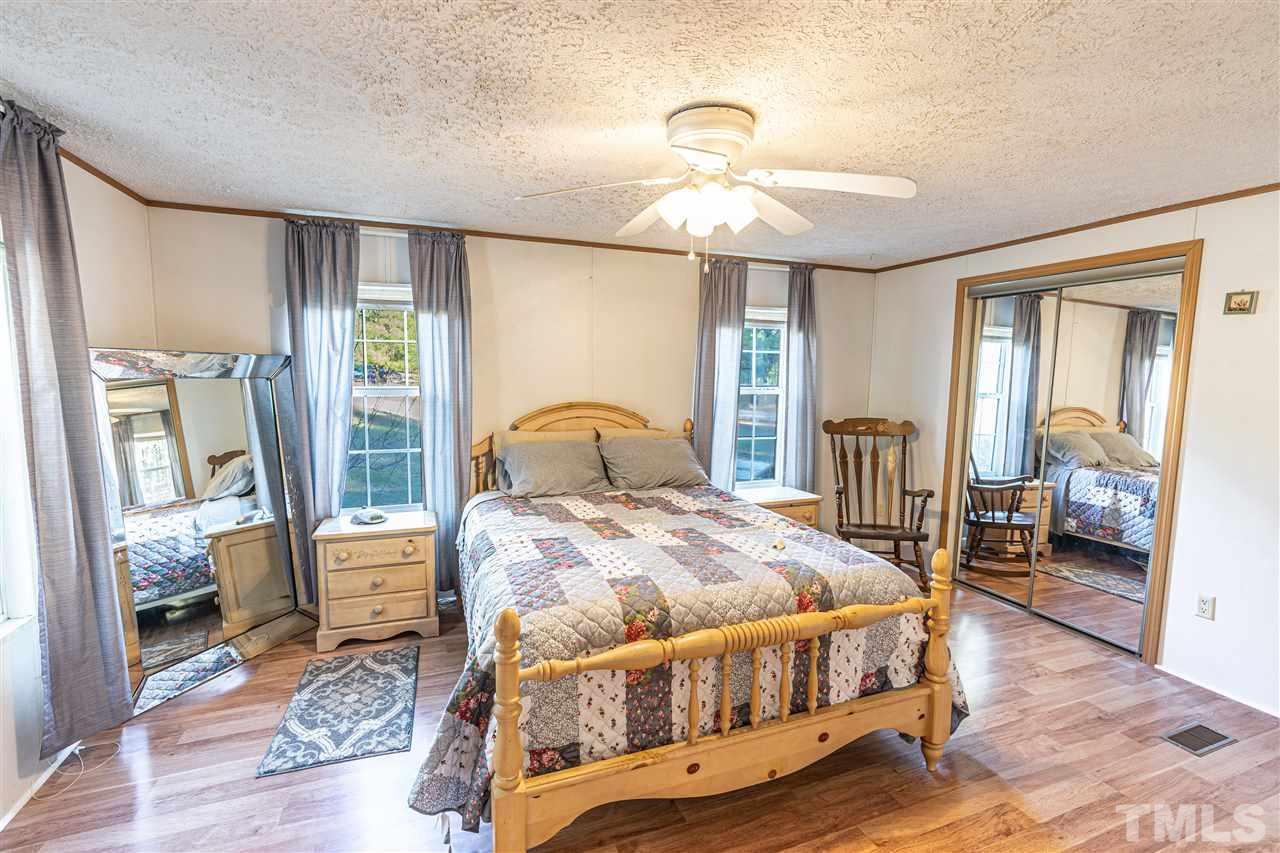 72 Cypress Farm Road Cameron, NC 28326 - Photo 15 of 28 a bedroom with a bed a table and flat screen tv