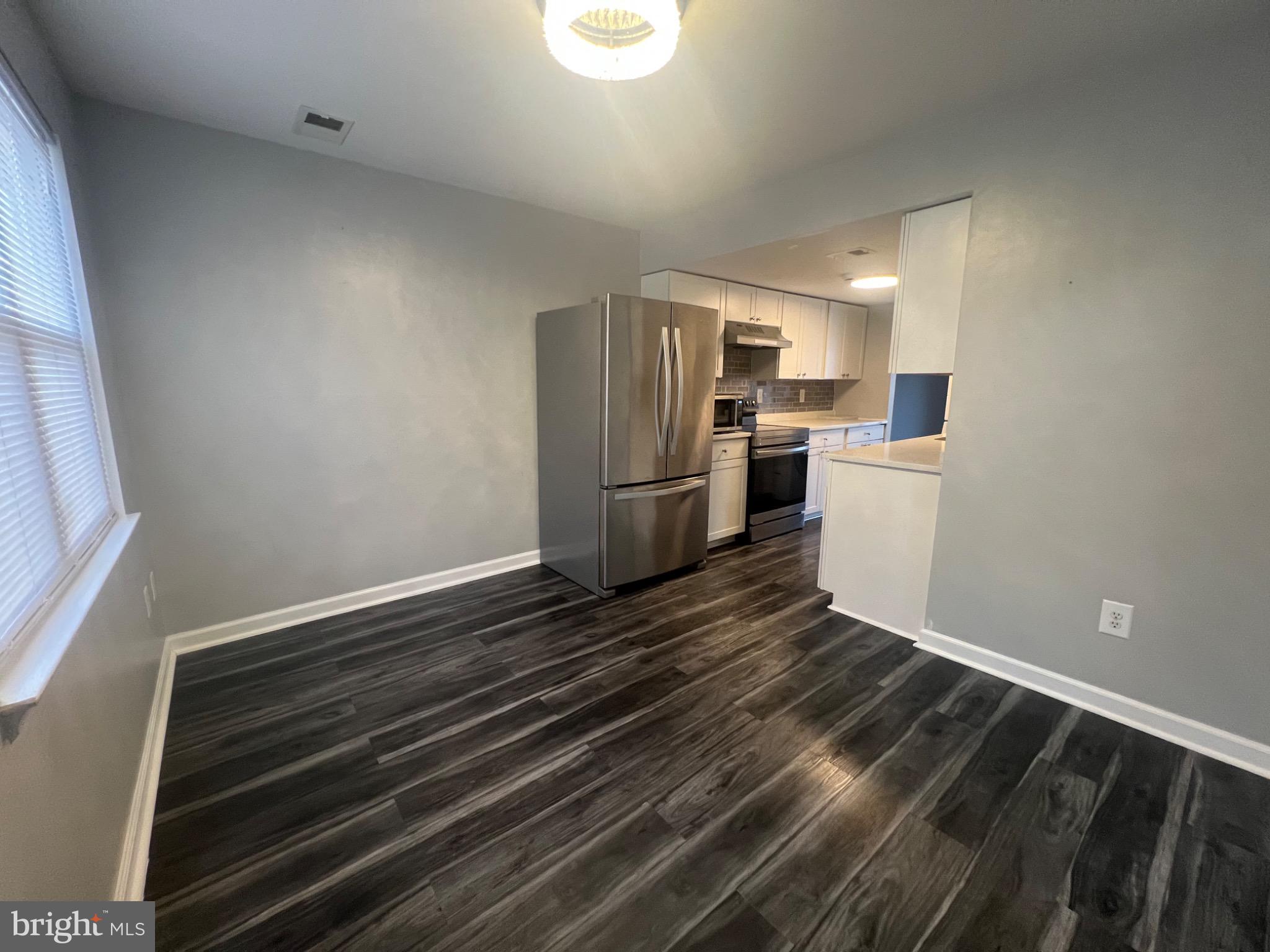 a kitchen with a refrigerator and white cabinets