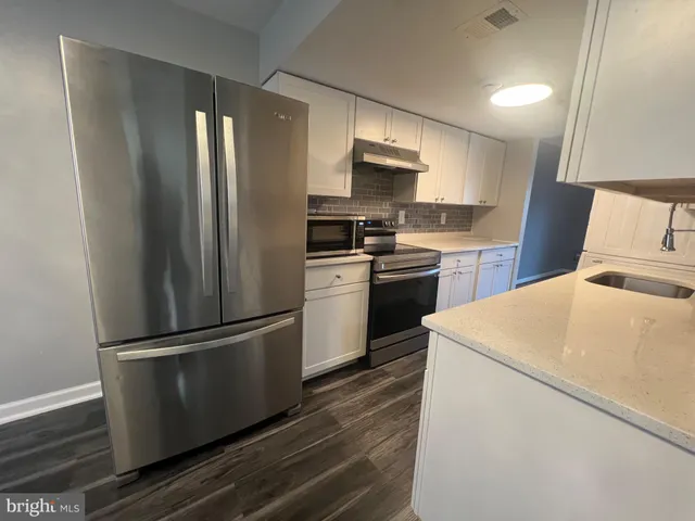 a kitchen with stainless steel appliances a refrigerator stove and microwave
