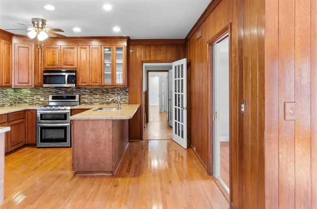 a kitchen with stainless steel appliances granite countertop a refrigerator a stove top oven a sink and dishwasher