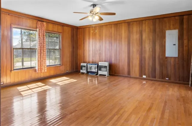 a view of an empty room with a window and wooden floor