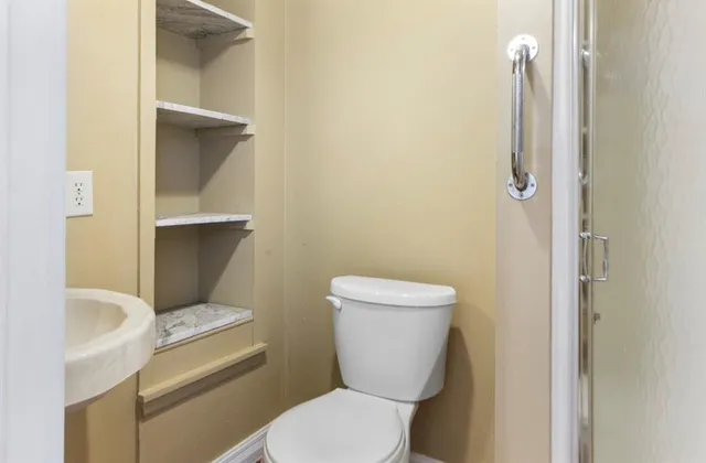 a white toilet sitting next to a bathroom sink