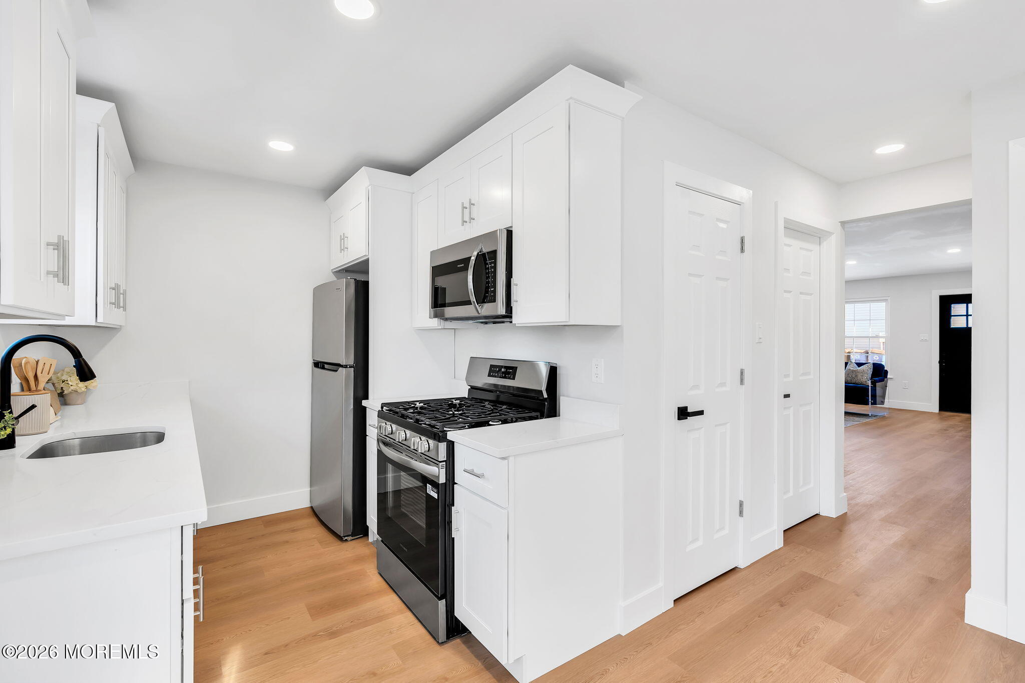 5 Jaffreyton Close Freehold, NJ 07728 - Photo 12 of 22 a kitchen with stainless steel appliances granite countertop a stove top oven a sink a refrigerator and white cabinets with wooden floor