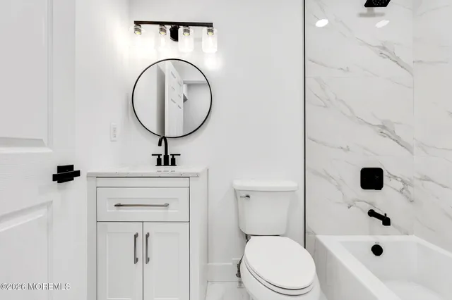 a bathroom with a sink a toilet and a mirror