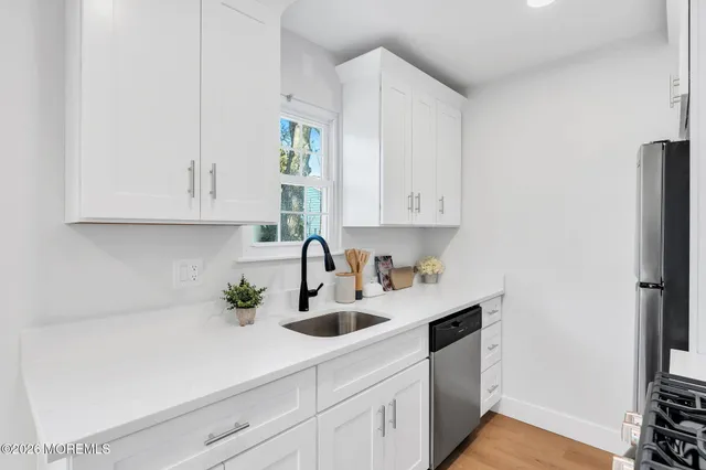 a kitchen with stainless steel appliances white cabinets and a sink