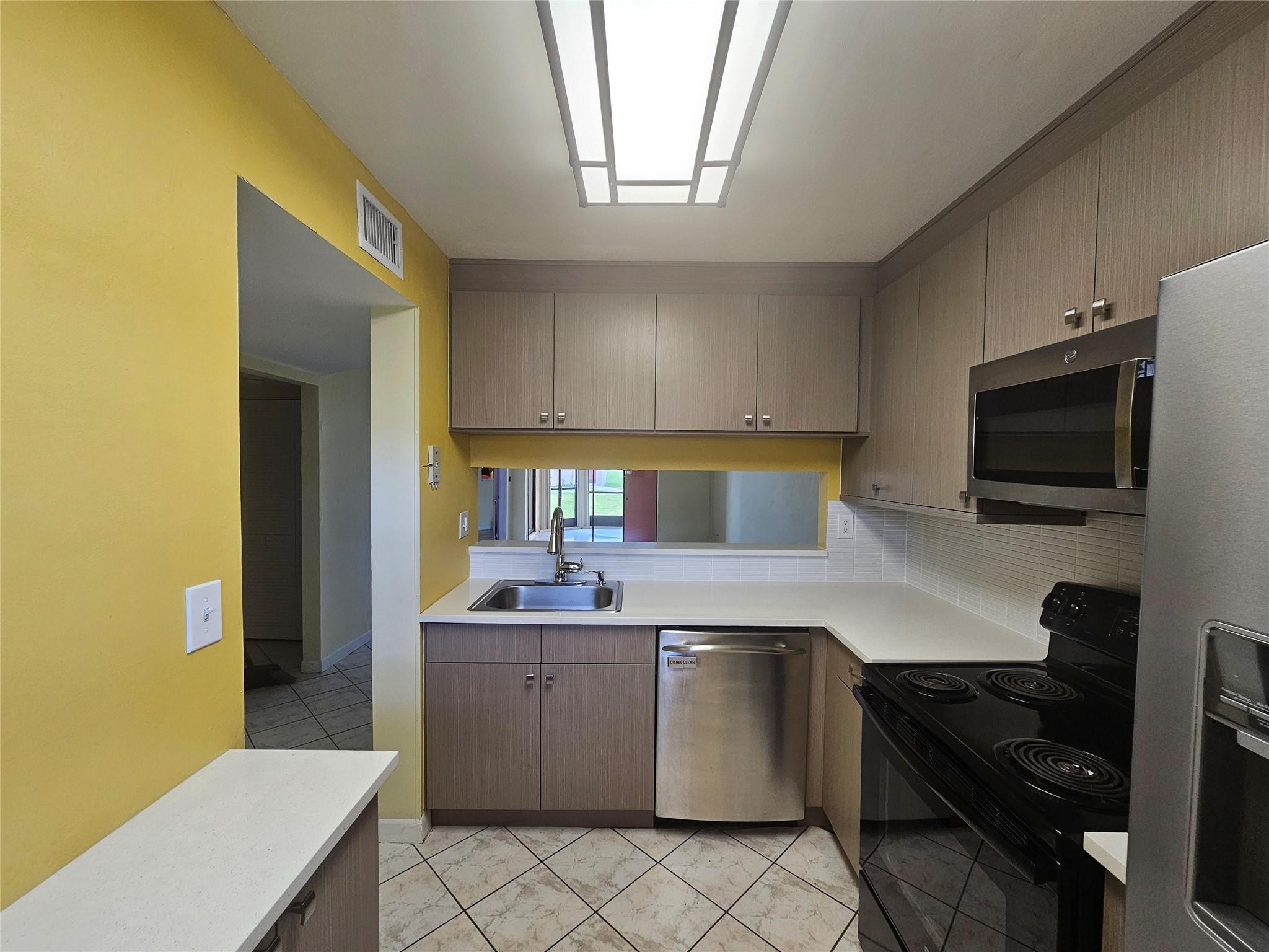 3396 Foxcroft Road, Unit 110 Miramar, FL 33025 - Photo 11 of 24 a kitchen with a sink and a stove top oven