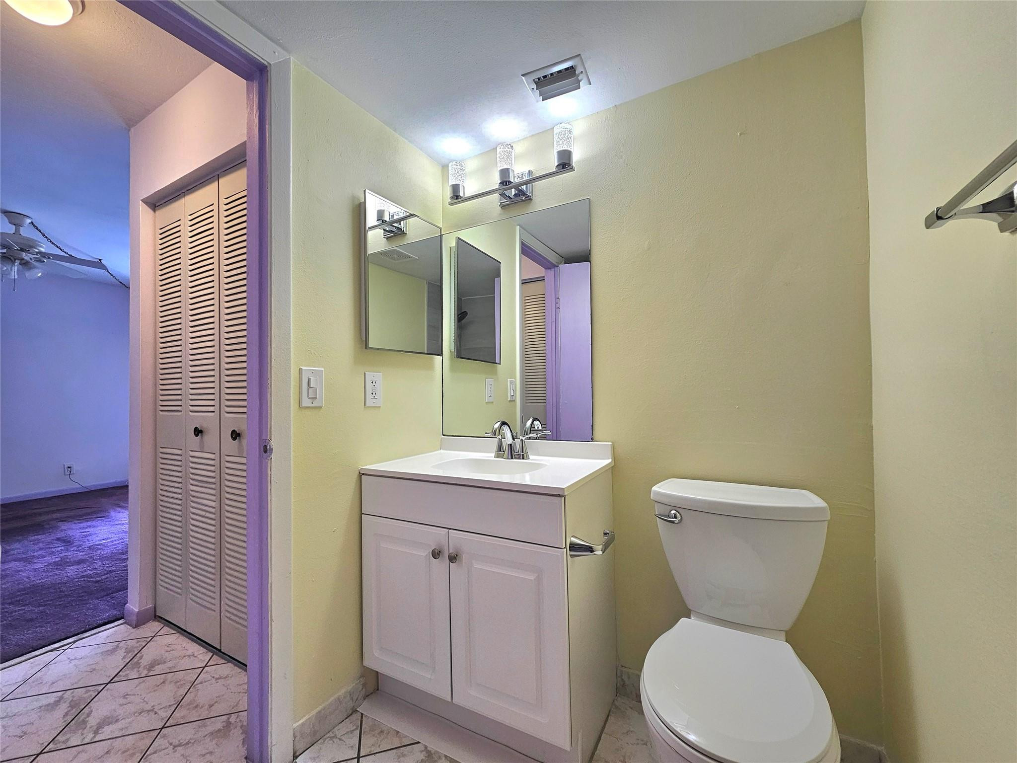 3396 Foxcroft Road, Unit 110 Miramar, FL 33025 - Photo 14 of 24 a bathroom with a toilet a sink and mirror
