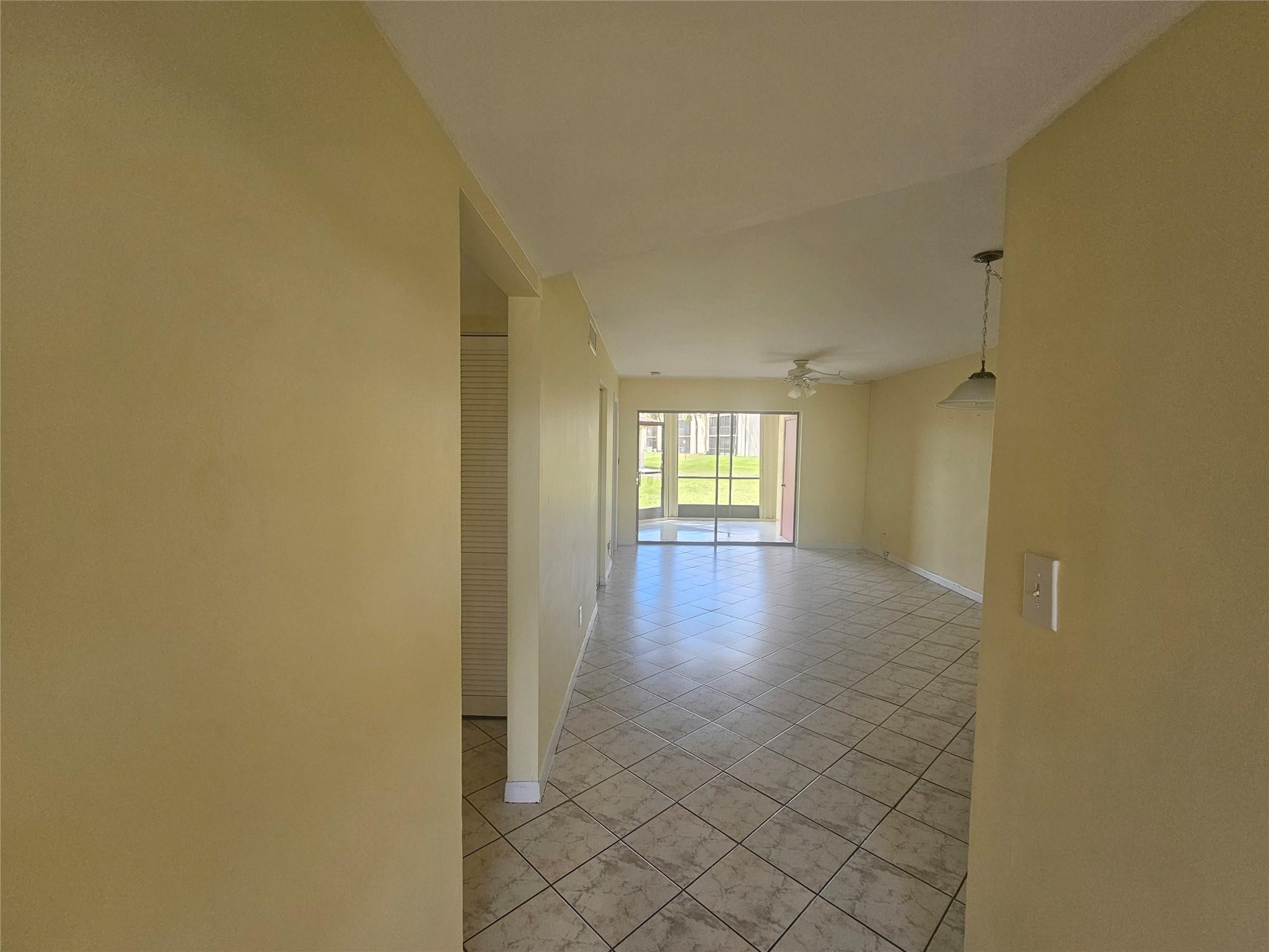 3396 Foxcroft Road, Unit 110 Miramar, FL 33025 - Photo 3 of 24 a view of a hallway with wooden floor and a living room