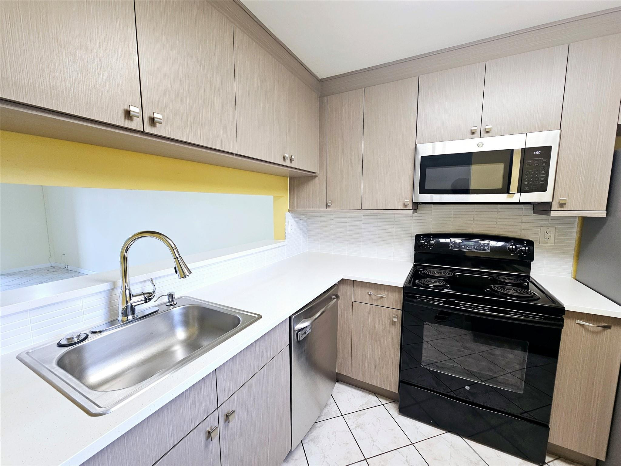3396 Foxcroft Road, Unit 110 Miramar, FL 33025 - Photo 7 of 24 a kitchen with granite countertop white cabinets and stainless steel appliances