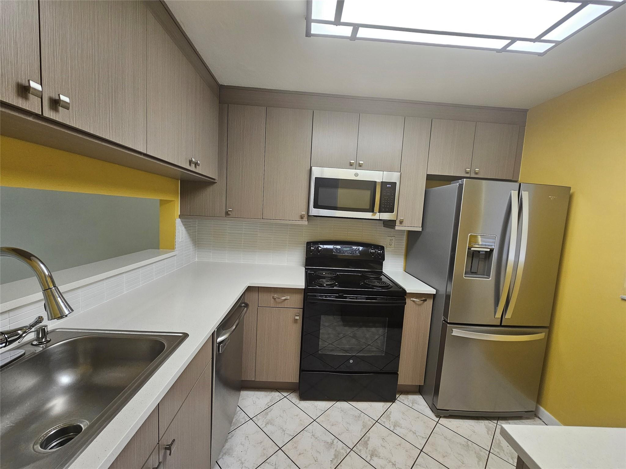3396 Foxcroft Road, Unit 110 Miramar, FL 33025 - Photo 8 of 24 a kitchen with granite countertop a refrigerator and a sink