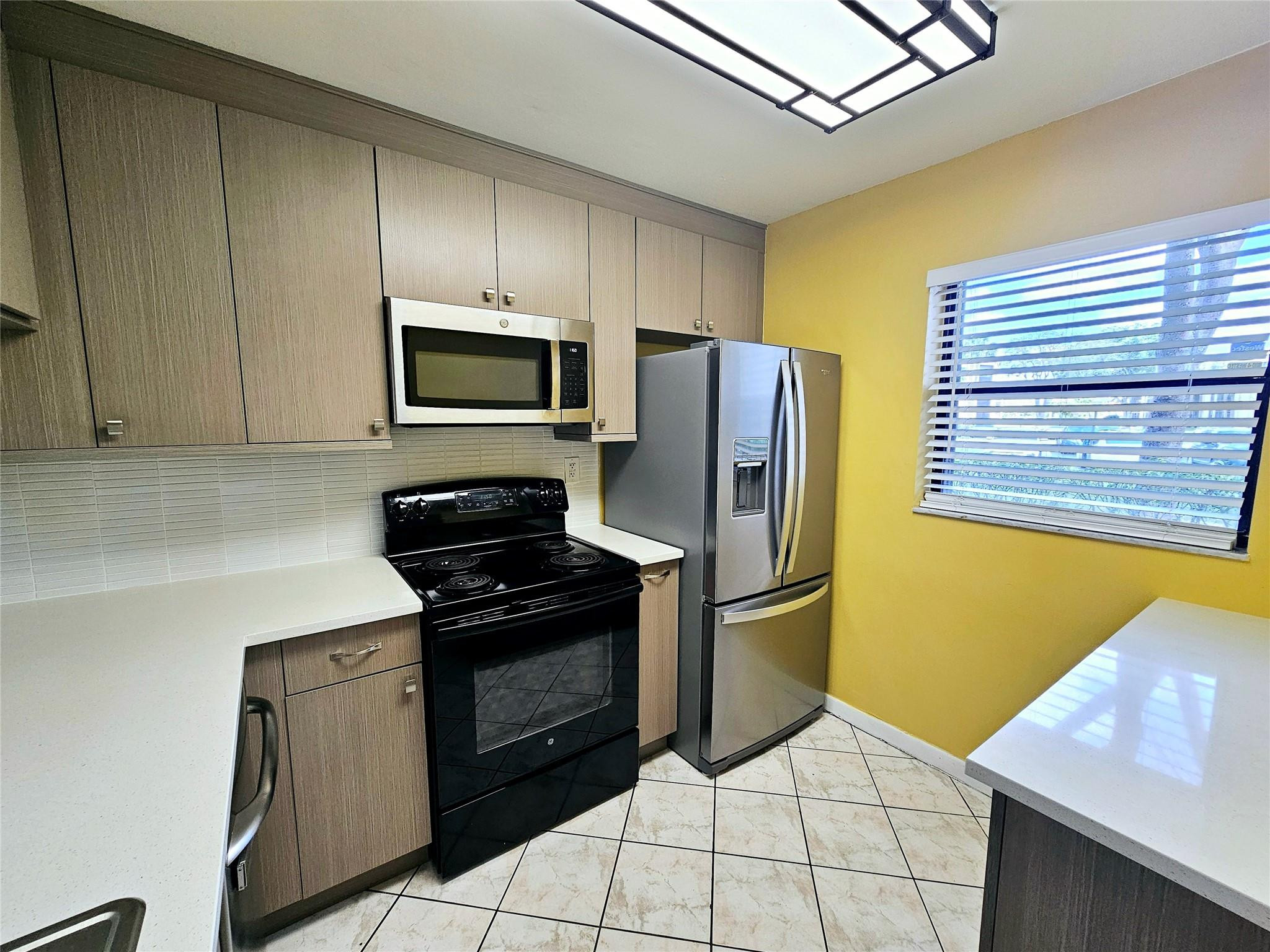 3396 Foxcroft Road, Unit 110 Miramar, FL 33025 - Photo 10 of 24 a kitchen with stainless steel appliances granite countertop a refrigerator stove and microwave