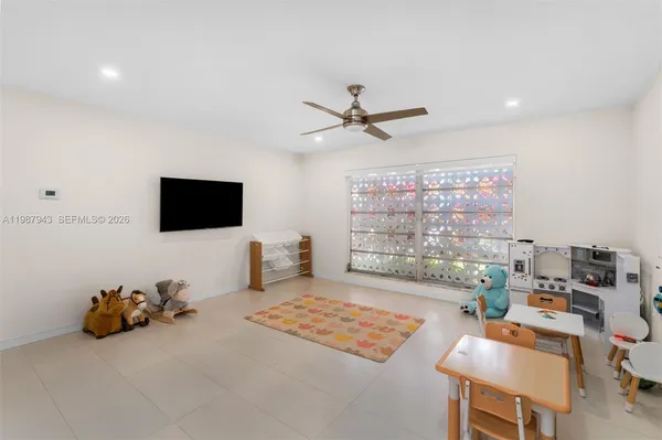 a living room with furniture a flat screen tv and a chandelier