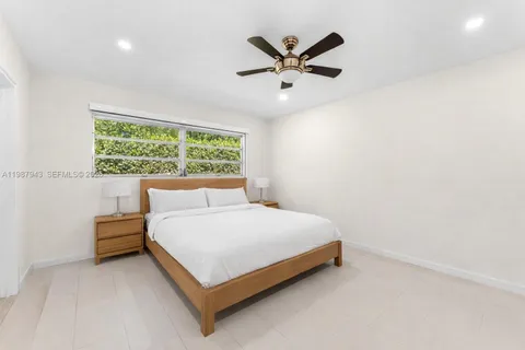 a bed sitting in a bedroom next to a window