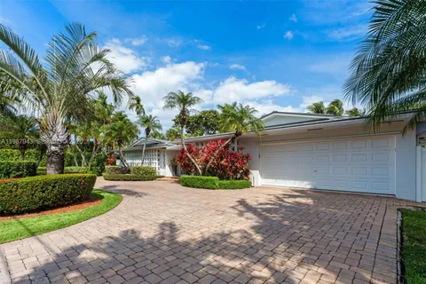 a front view of a house with a yard and potted plants