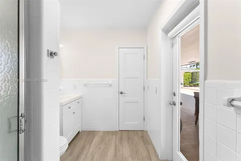 a view of a hallway with wooden floor and closet
