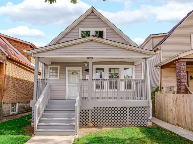 a view of a house with a small yard and wooden fence