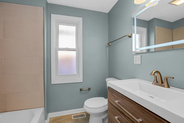 a bathroom with a toilet sink and mirror