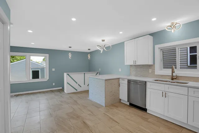 a large white kitchen with sink and window