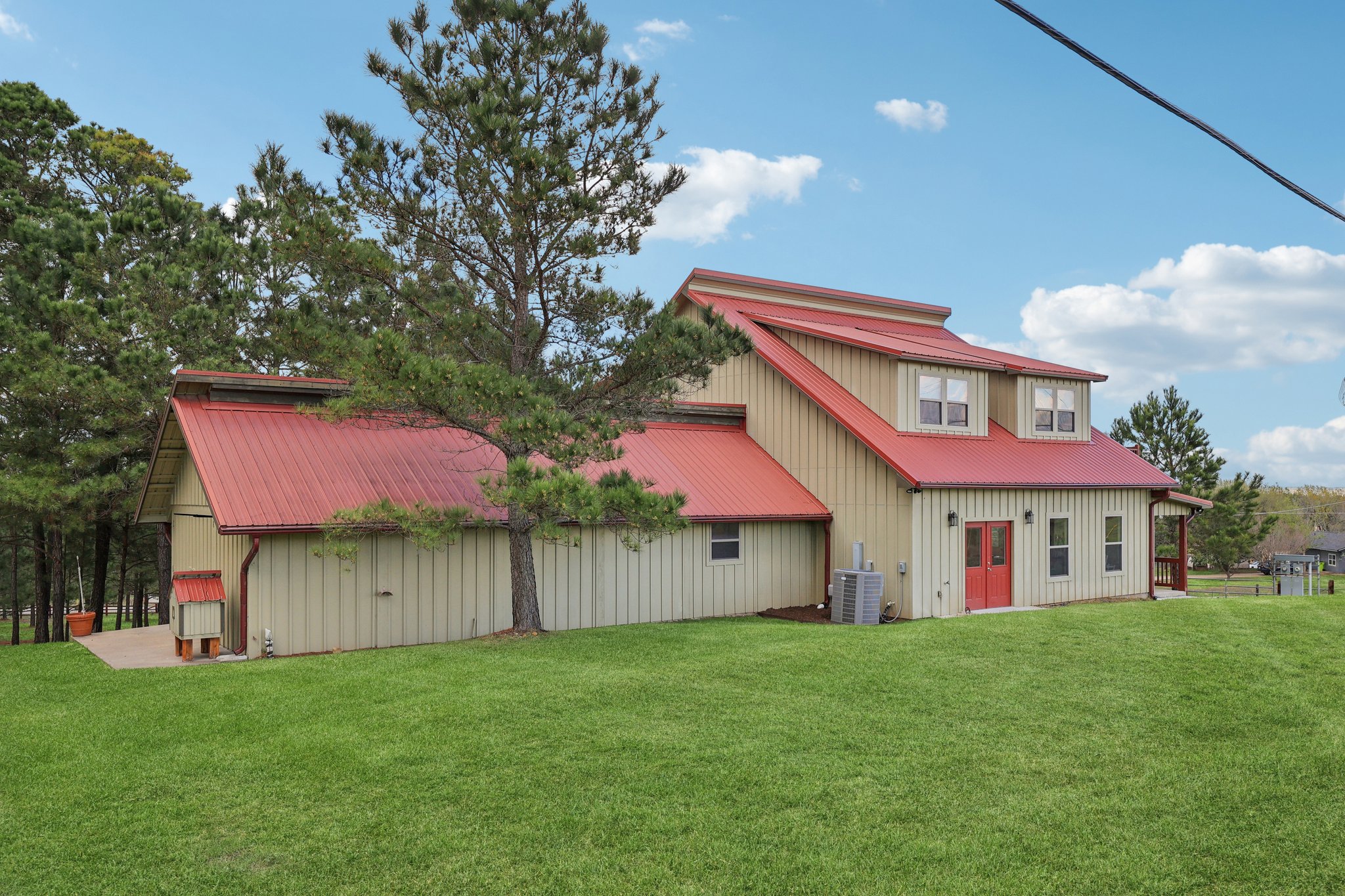 546 McAllister Road Bastrop, TX 78602 - Photo 33 of 40 Back of house with a metal roof, a lawn, and board and batten siding