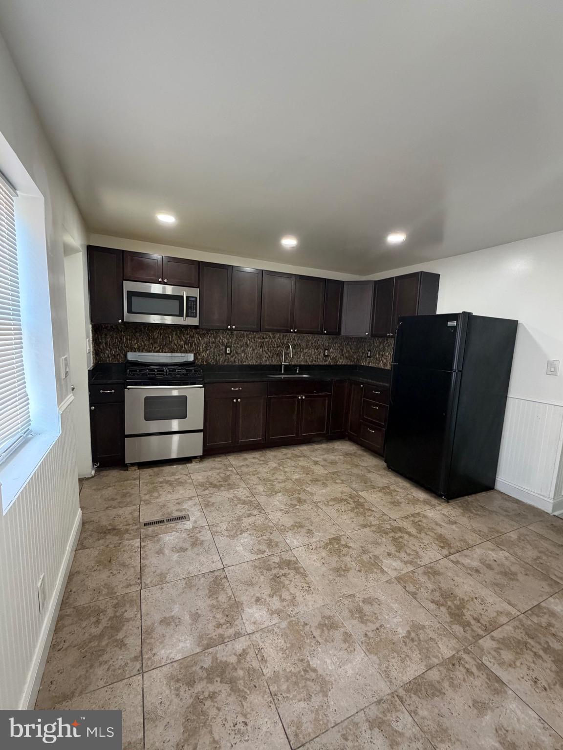 1626 Inverness Avenue Baltimore, MD 21230 - Photo 11 of 19 a large kitchen with kitchen island granite countertop a refrigerator and a stove top oven
