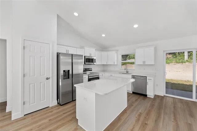 a kitchen with white cabinets and stainless steel appliances