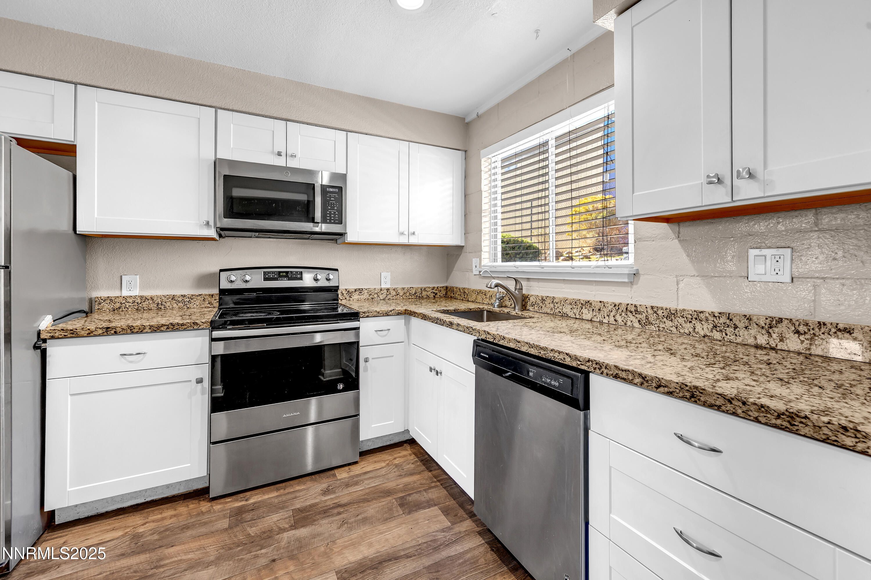 1436 East 9th Street, Unit 8 Reno, NV 89512 - Photo 11 of 19 a kitchen with stainless steel appliances granite countertop white cabinets a sink and a stove