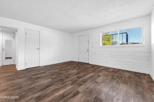 a view of empty room with wooden floor and ceiling fan