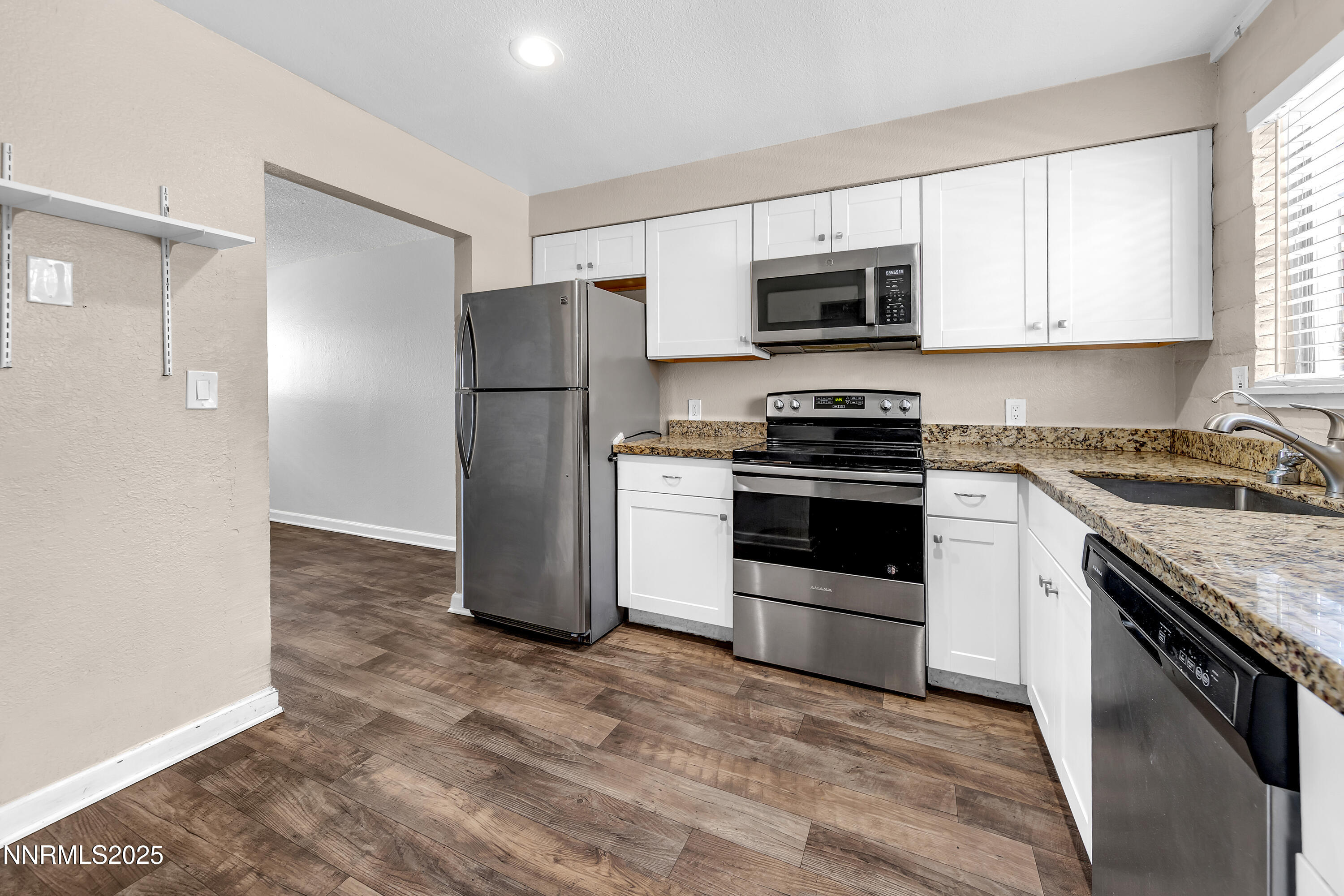 1436 East 9th Street, Unit 8 Reno, NV 89512 - Photo 10 of 19 a kitchen with granite countertop a refrigerator stove and microwave