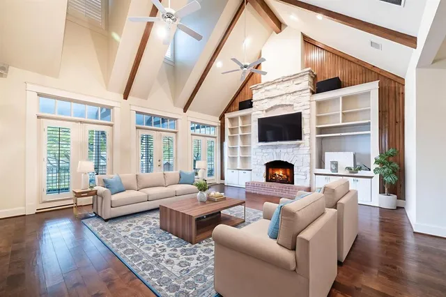 a view of an empty room with wooden floor and a fireplace