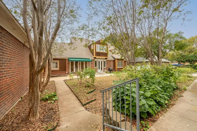 a view of swimming pool with lawn chairs and large trees