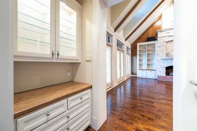a view of a room with wooden floor a ceiling fan and windows
