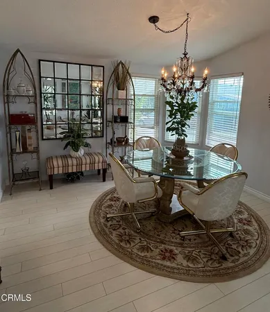 a view of a dining room with furniture a chandelier and wooden floor