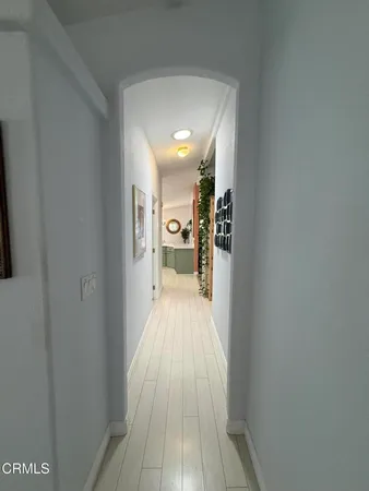 a view of a hallway with wooden floor a living room