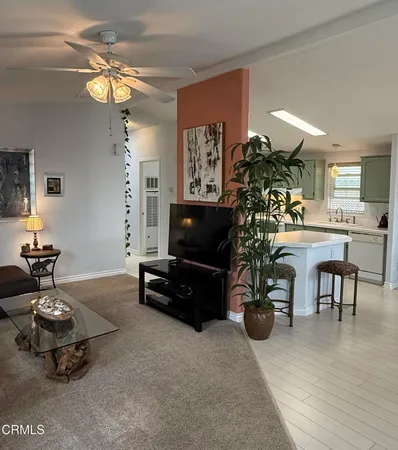 a living room with furniture a chandelier and a flat screen tv