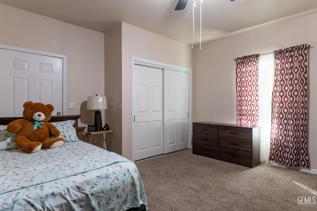 a bedroom with a bed and a flat tv screen on dresser