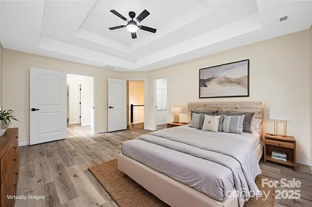 a spacious bedroom with a large bed and a chandelier