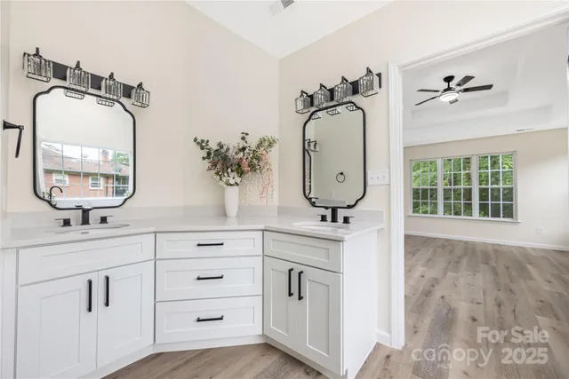 a bathroom with a double vanity sink mirror and bathtub