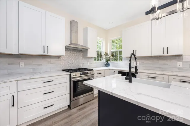 a kitchen with granite countertop a sink a stove and cabinets
