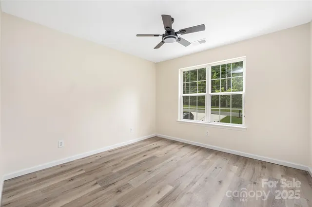 a view of a room with wooden floor and windows