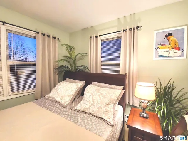 a bedroom with a bed and a painting on the wall