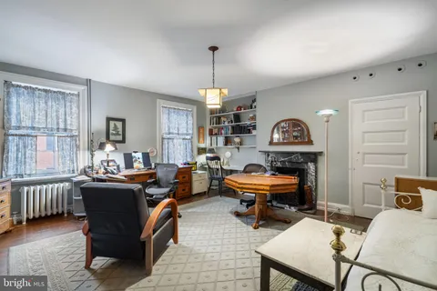 a living room with furniture a piano and a window