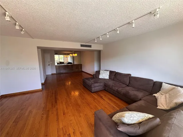 a living room with furniture and a wooden floor