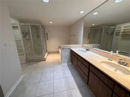 a spacious bathroom with a granite countertop sink a mirror and a shower