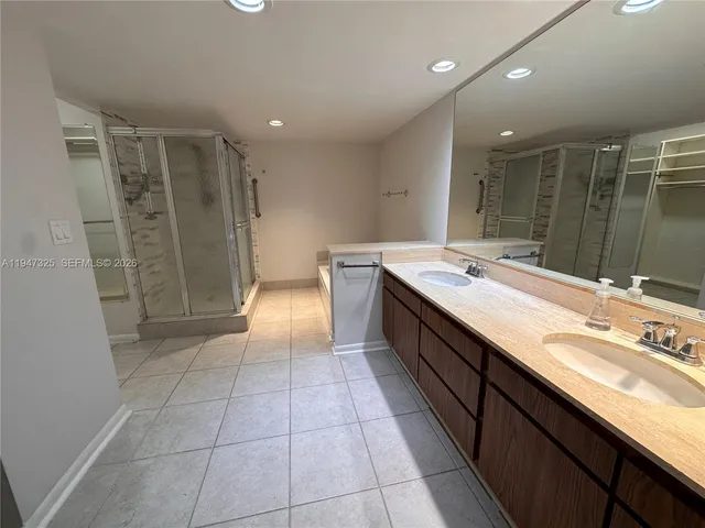 a spacious bathroom with a granite countertop sink a mirror and a shower
