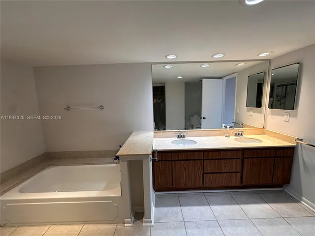 a bathroom with a tub sink and mirror