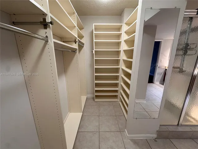 a view of walk in closet with empty racks