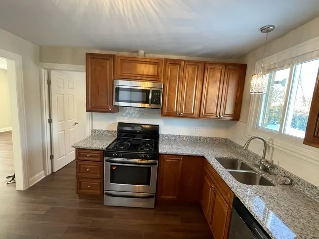 a kitchen with granite countertop a sink and steel appliances