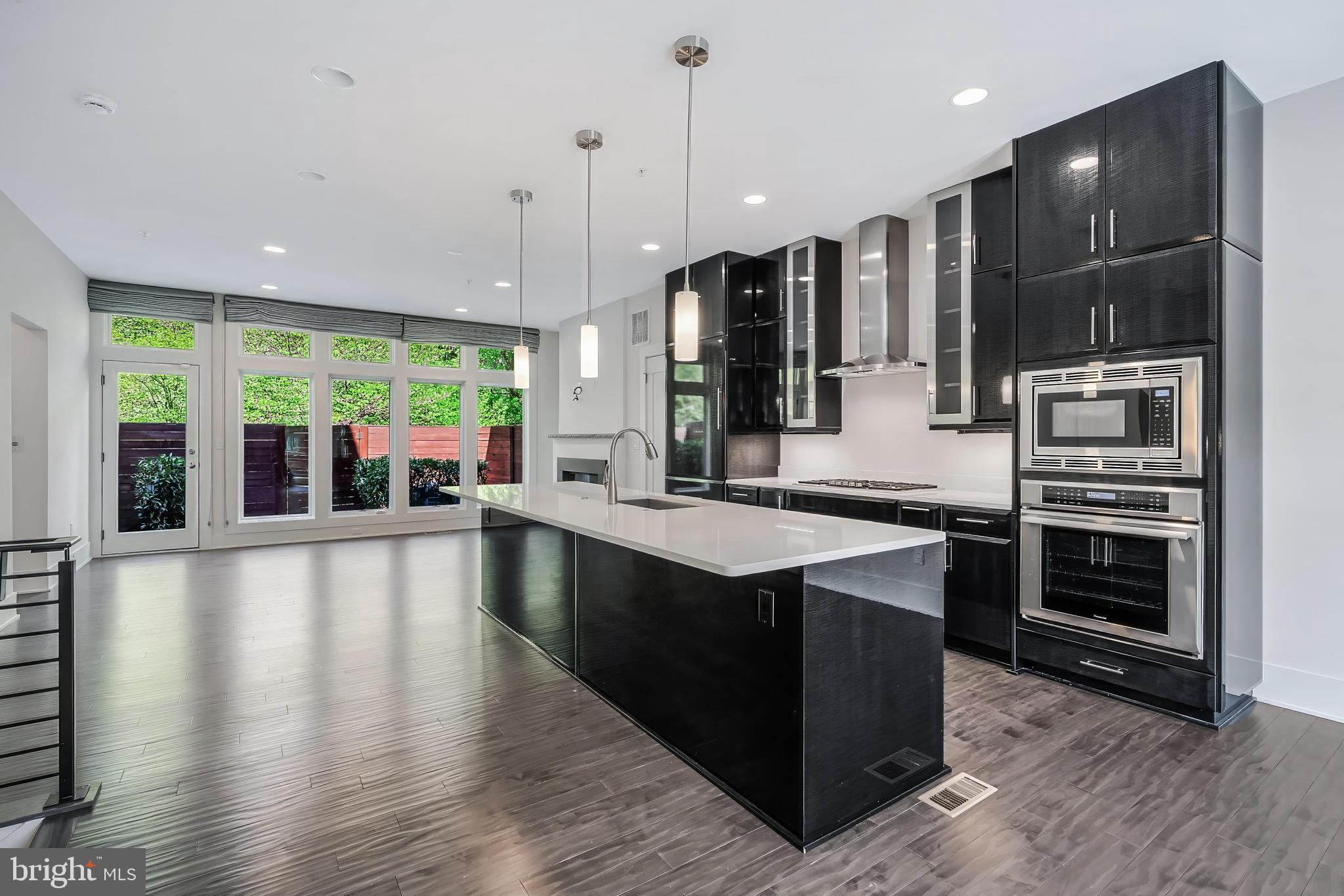 5125 Willet Bridge Road Bethesda, MD 20816 - Photo 7 of 47 a large kitchen with stainless steel appliances a large counter top a stove and a wooden floors