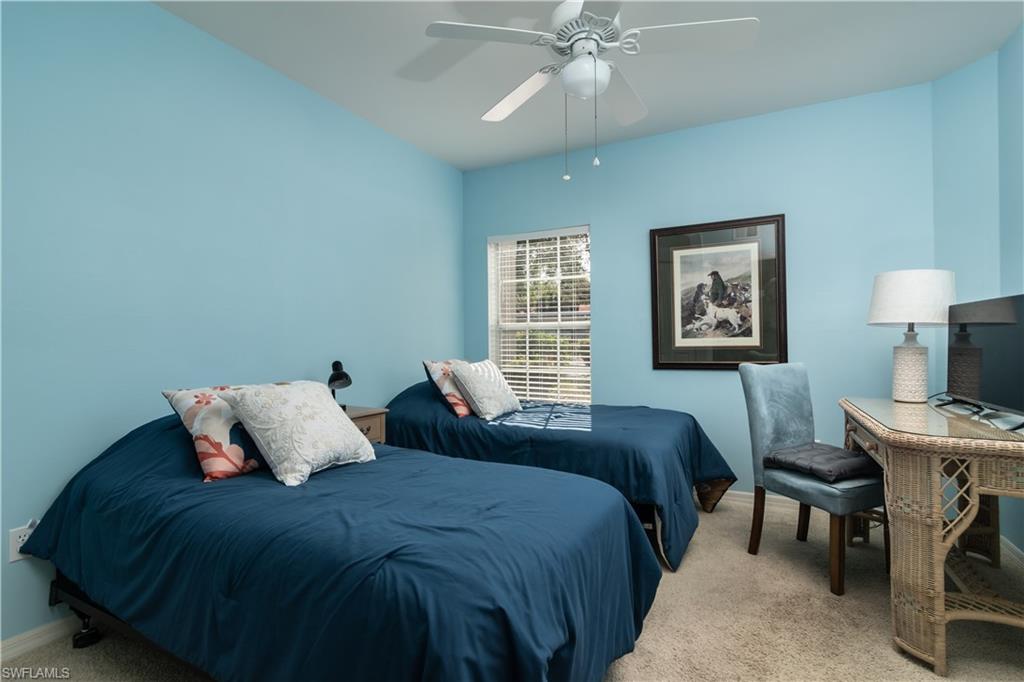 2585 Old Groves Road, Unit L102 Naples, FL 34109 - Photo 11 of 29 a bedroom with a bed and a table in it with window
